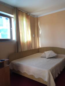 a bedroom with a large bed with a window at Casa Petre in Eforie Nord