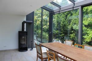 ein Esszimmer mit einem Tisch und einem Holzofen in der Unterkunft Ferienhaus mit eigenem Garten und Terrasse in Lindau-Bodolz