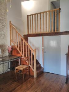 a wooden staircase in a room with a chair at gîte 4 chambres à Cognac in Cognac