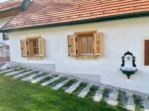 a white house with two windows and a staircase at Ferienhaus Perwolff in Eisenberg an der Pinka