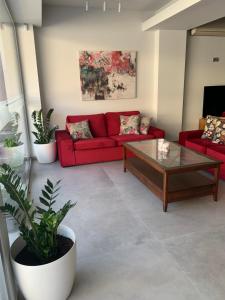 ein Wohnzimmer mit einem roten Sofa und einem Couchtisch in der Unterkunft Petra Hotel in Agia Galini