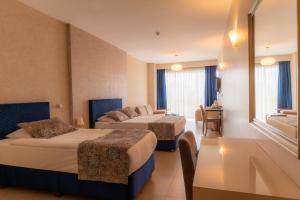 a hotel room with two beds and a table at Grand Karot Hotel in Yalova
