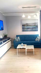 a living room with a blue couch and a table at Moje Miejsce in Gdańsk