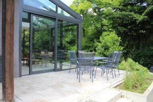 un patio con sillas y una mesa con puertas de cristal en Ferienhaus mit eigenem Garten und Terrasse, en Lindau-Bodolz