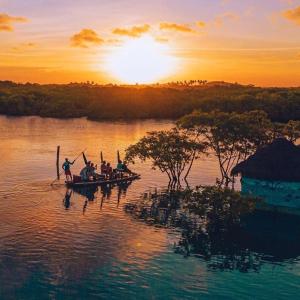 een groep mensen in boten op het water bij zonsondergang bij Pousada da Vivi in Maracaipe +16 foto's