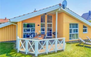 ein kleines gelbes Haus mit einer großen Terrasse in der Unterkunft Strandblick 28 in Schönhagen