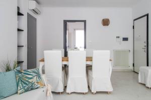 uma sala de jantar com paredes brancas e uma mesa e cadeiras em Elios by PortofinoHomes em Portofino
