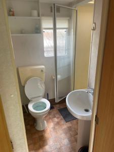 a bathroom with a toilet and a sink at DOMKI HOLENDERSKIE U Borysa in Pobierowo