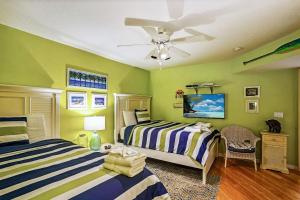 een slaapkamer met 2 bedden en een plafondventilator bij Oceanside 302 in Clearwater Beach