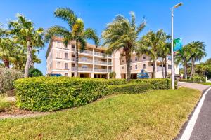 a large building with palm trees in front of it at Oceanside 302 in Clearwater Beach