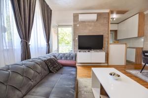 a living room with a couch and a television at Apartman Darija 1 in Trebinje