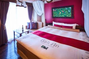 Hotel BaliAn Resort Yokohama Kannai - Adult Only في يوكوهاما: غرفة نوم بسرير بجدار احمر