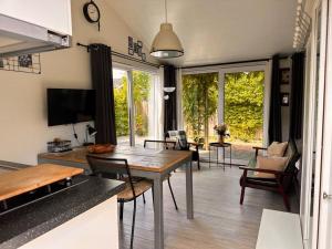 un soggiorno con tavolo e sedie in legno di Coast Holiday Appartements a Dirkshorn