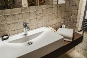 La salle de bains est pourvue d'un lavabo blanc et d'un miroir. dans l'établissement La Piazzetta Affittacamere Ristorante, à Anagni