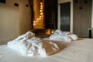 dwa białe ręczniki siedzące na łóżku w obiekcie La Piazzetta Affittacamere Ristorante w mieście Anagni