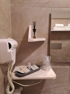 um telefone sentado numa prateleira na casa de banho em Hotel Lo Smeraldo em Roccavivara