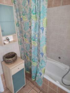 uma casa de banho com uma cortina de chuveiro ao lado de uma banheira em Blue and white apartments 3 em Benitses