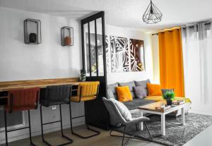 ein Wohnzimmer mit einem Sofa und einem Tisch in der Unterkunft Appartement nouveaux quartier Bologne à deux pas de Mosson, WiFi, climatisation et parking gratuit in Montpellier