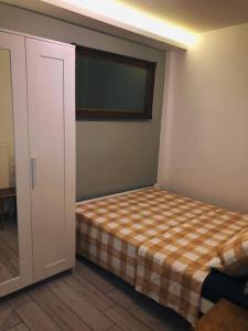 um quarto com uma cama com um cobertor xadrez em David's House em Tessalônica