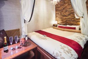 a bedroom with a bed with wine glasses on a table at Hotel BaliAn Resort Yokohama Kannai - Adult Only in Yokohama