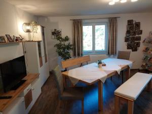 una sala da pranzo con tavolo e TV di Ferienhaus Silvia Jesse a Sankt Kanzian