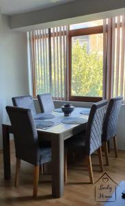 mesa de comedor y sillas con ventana en Lindy Home en Burgas