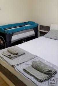 Dos camas con toallas encima. en Lindy Home en Burgas
