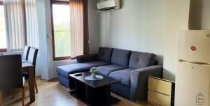 a living room with a blue couch and a table at Lindy Home in Burgas