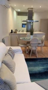sala de estar con 2 sofás blancos y cocina en Apartament en Plaça Nova 2, Palafrugell, en Palafrugell