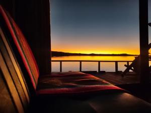 um quarto com uma janela com vista para o pôr-do-sol em Titicaca Aruntawi Lodge Peru em Puno