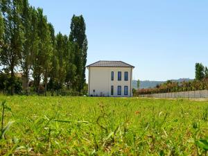 una pequeña casa blanca en un campo de hierba en Nerium Garden Inn Tirana Airport en Rinas