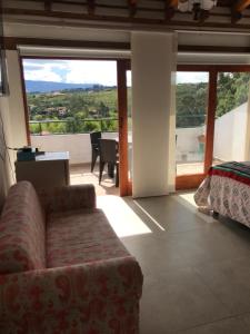 a living room with a couch and a large window at Casa de Campo Villa Bonita hotel in Villa de Leyva