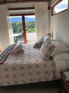 a bedroom with a bed and a large window at Casa de Campo Villa Bonita hotel in Villa de Leyva