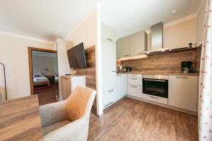 a kitchen with white cabinets and a stove top oven at Pension Gletscherblick in Fulpmes