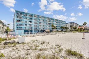 a building on the beach next to a beach at Sand Dollar 107 in Clearwater Beach