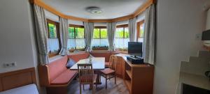 Zimmer mit Sofa, Tisch und TV in der Unterkunft Appartement Margreiter in Niederau