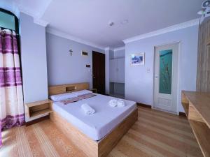 1 dormitorio con 1 cama y 1 cruz en la pared en Ging-Ging Tourist Inn, en Badian