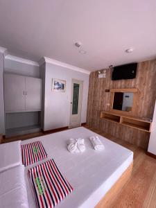 1 dormitorio con 1 cama blanca grande y toallas. en Ging-Ging Tourist Inn, en Badian