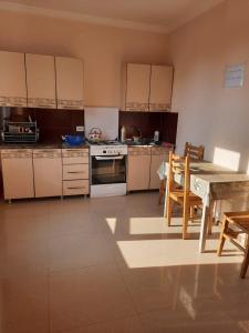 a kitchen with white cabinets and a table and chairs at TEGI in Ureki