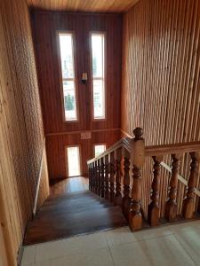 a staircase in a house with wooden walls and windows at TEGI in Ureki