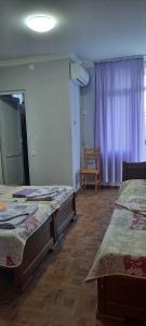 um quarto com 2 camas e uma cortina roxa em TEGI em Ureki
