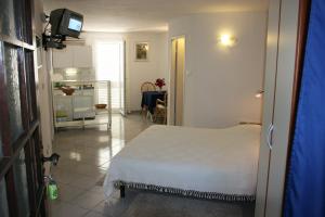 1 dormitorio con 1 cama blanca y sala de estar en Apartment Dubravka, en Podgora