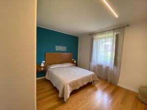 1 dormitorio con cama y pared azul en Casa vacanze da Mary, en Badia Prataglia