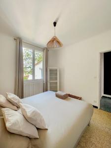 ein großes weißes Bett in einem Schlafzimmer mit Fenster in der Unterkunft La Bohème à Lacoste in Lacoste