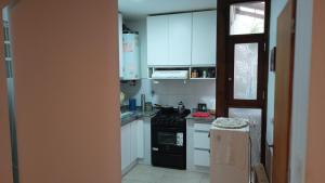 a kitchen with white cabinets and a black stove top oven at MdP, 2 dorm, 4 pers, 2 cuadras de la playa in Mar del Plata