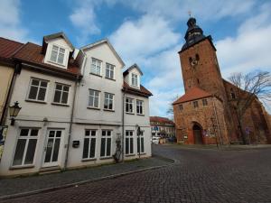 a building with a clock tower on a street at Ferienwohnung Havel-Ausblick in Havelberg