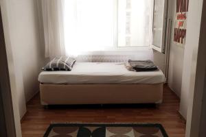 a bed in a small room with a window at Our flat is located in Beşiktaş Square. in Istanbul