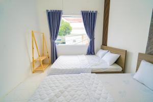 two beds in a room with a window at LP Villa 51 - Free Karaoke - Bida - Gần Bãi Sau in Vung Tau +15 photos