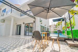 a patio with a table and chairs and an umbrella at LP Villa 51 - Free Karaoke - Bida - Gần Bãi Sau in Vung Tau