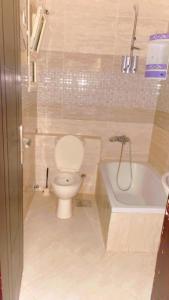 a bathroom with a toilet and a bath tub at شاليهات لاسيرينا ثلاث غرف ارضي بحديقة in Suez